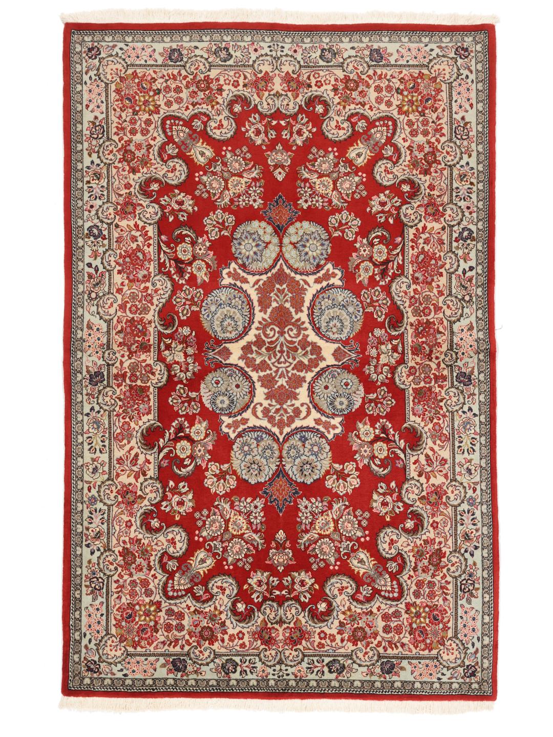 A hand-knotted red Sarough rug with intricate floral patterns.