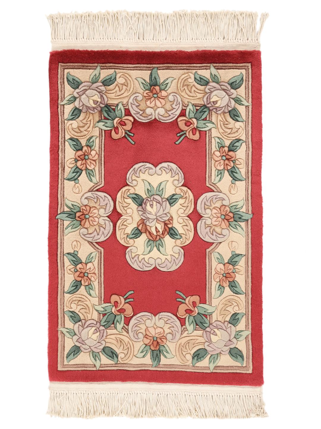 Håndknyttet kinesisk tæppe med blomstermotiver i røde, beige og grønne nuancer.