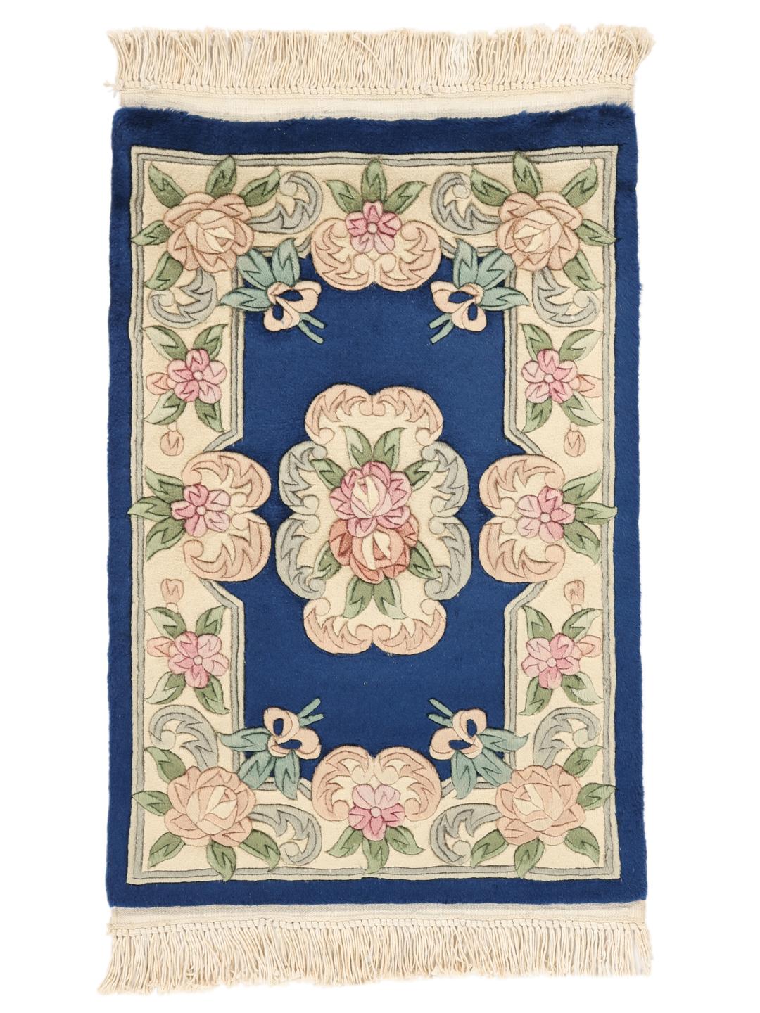 Håndknyttet blomstret tæppe fra Kina med blå bund og pastelfarvede blomster.