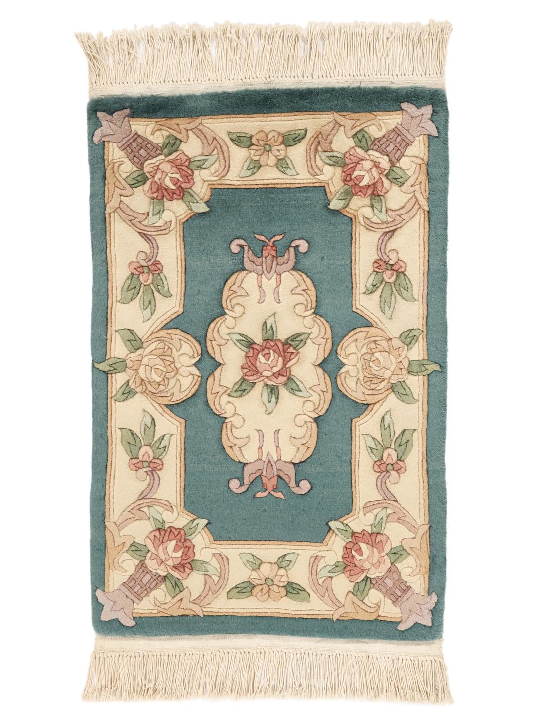 Et håndknyttet kinesisk tæppe med blomstermotiver i teal og beige.