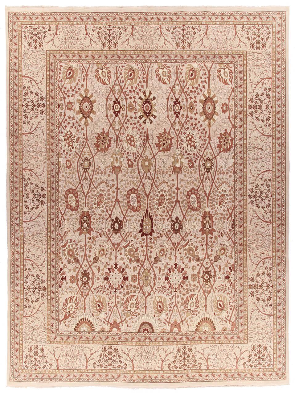 Et stort rektangulært håndknyttet tæppe fra Indien med et indviklet blomstermønster i beige og bløde røde toner.