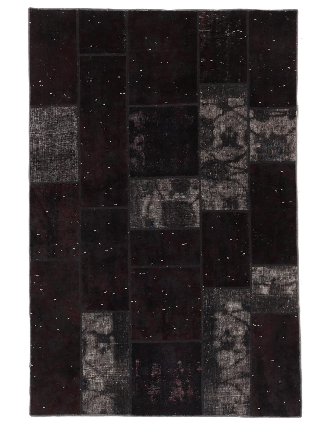 A rectangular patchwork rug from the Middle East in black and dark-grey tones.
