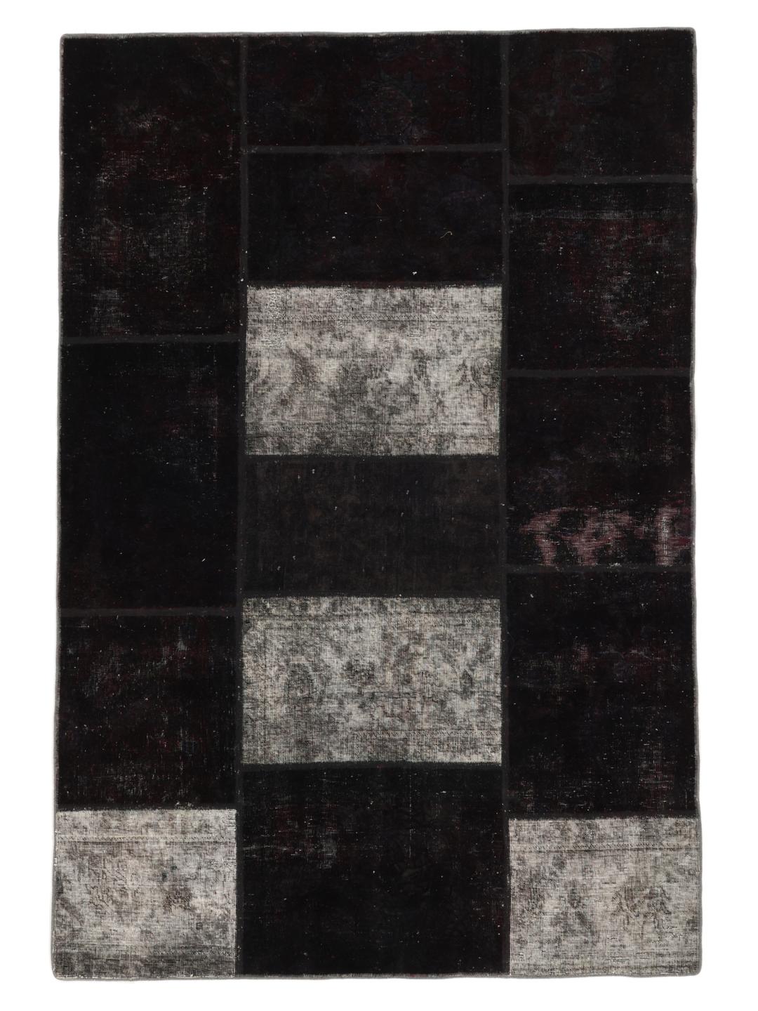 A rectangular patchwork rug from the Middle East featuring a black and grey colour palette.