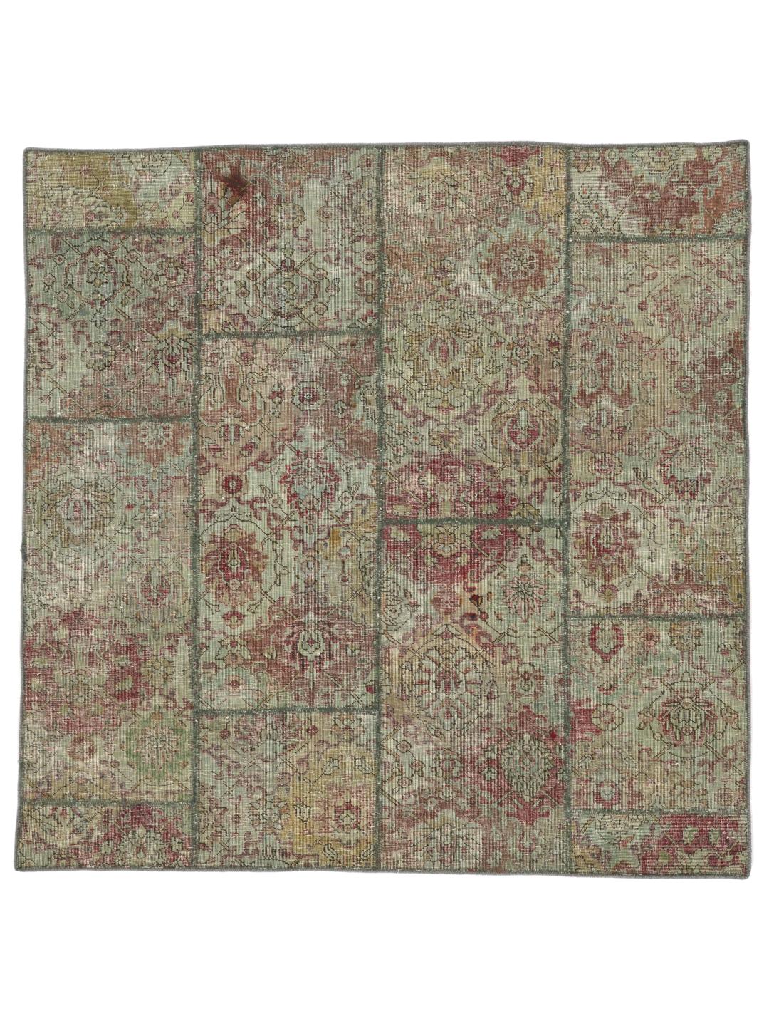 Et kvadratisk, flerfarget patchwork-teppe laget av vintage-fragmenter.