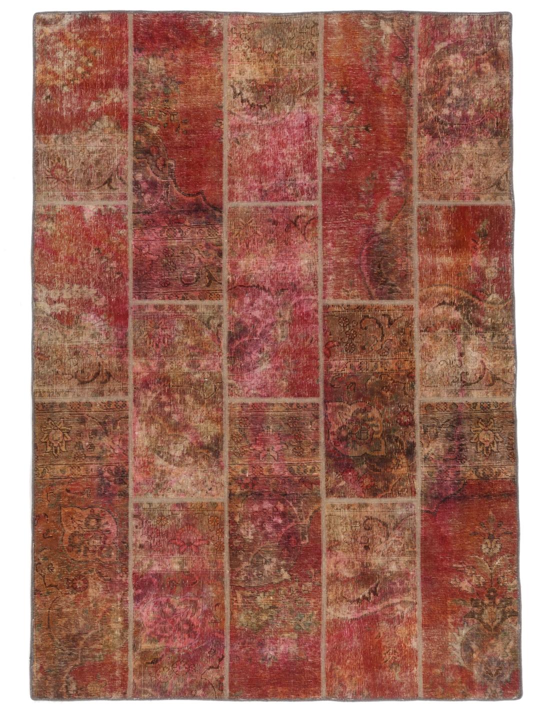 Et rødt og brunt patchwork-tæppe med forskellige vintage-tekstilfragmenter fra Mellemøsten.