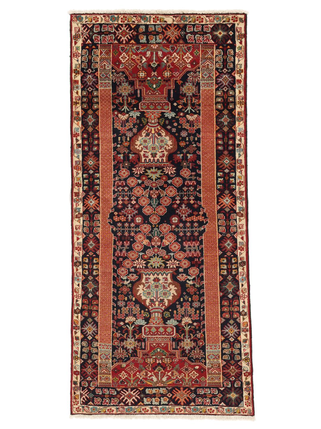 A hand-knotted Qashqai runner featuring traditional tribal motifs in deep red and navy blue.