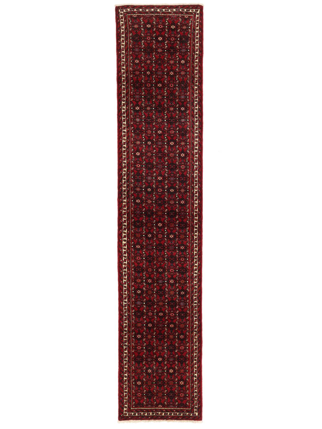 A hand-knotted Middle Eastern runner rug in deep red with intricate geometric patterns.