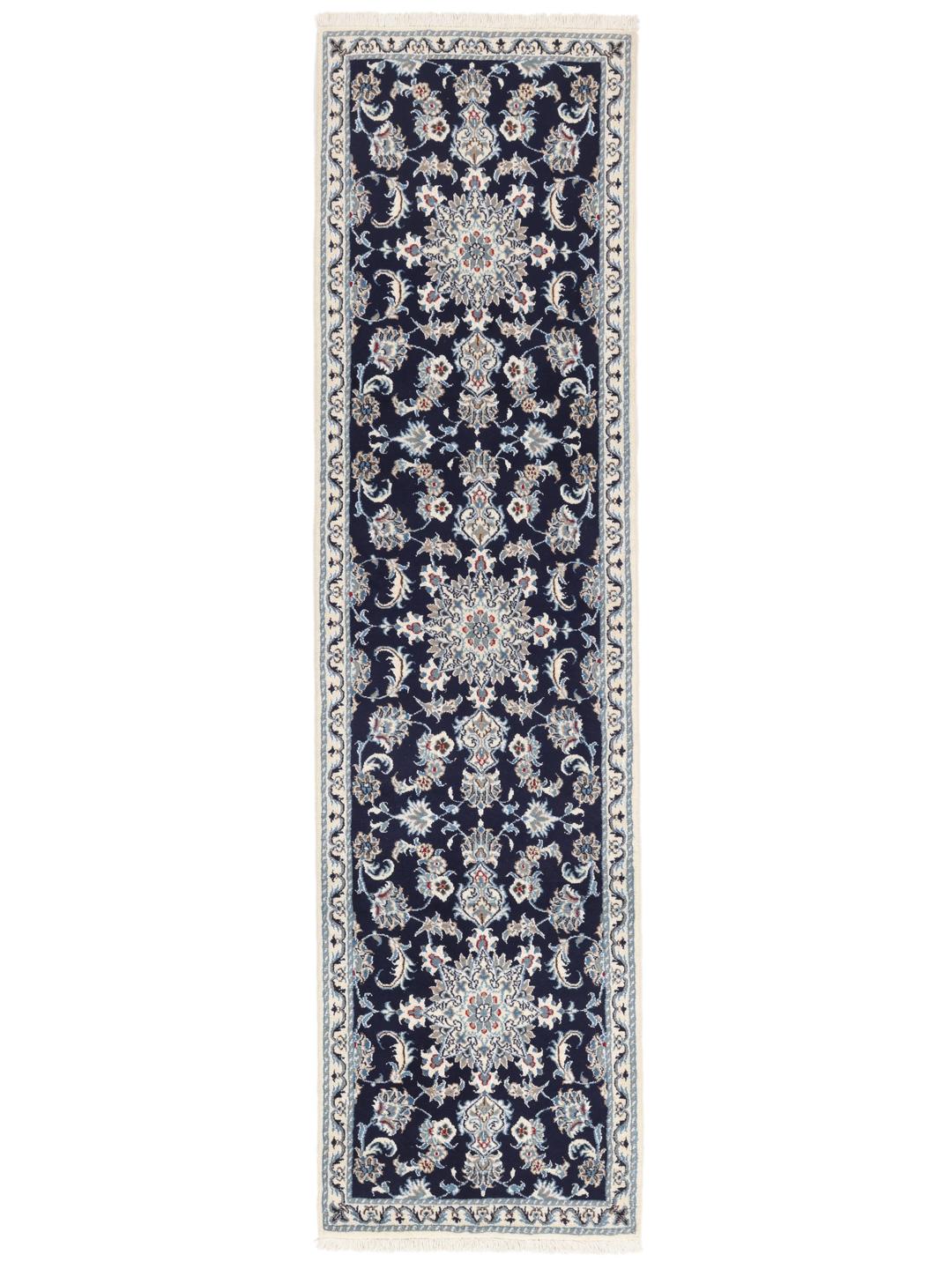 A hand-knotted Nain runner from the Middle East in dark blue with floral patterns.