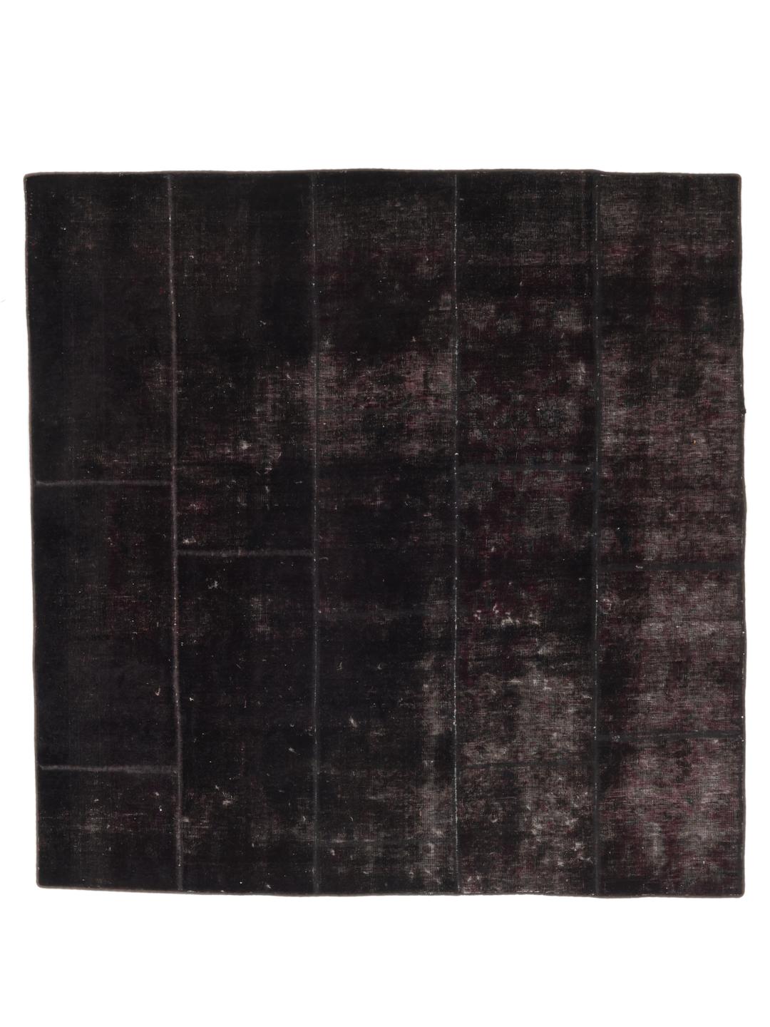 Een vierkant zwart patchwork vloerkleed afkomstig uit het Midden-Oosten.