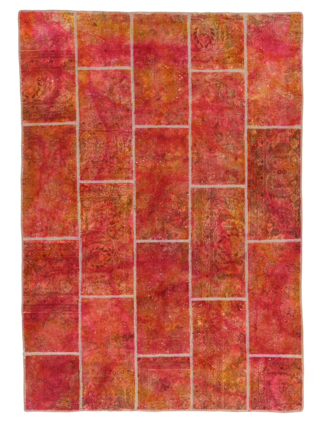 A vibrant red and orange patchwork rug with intricate patterns and a textured Wool pile.