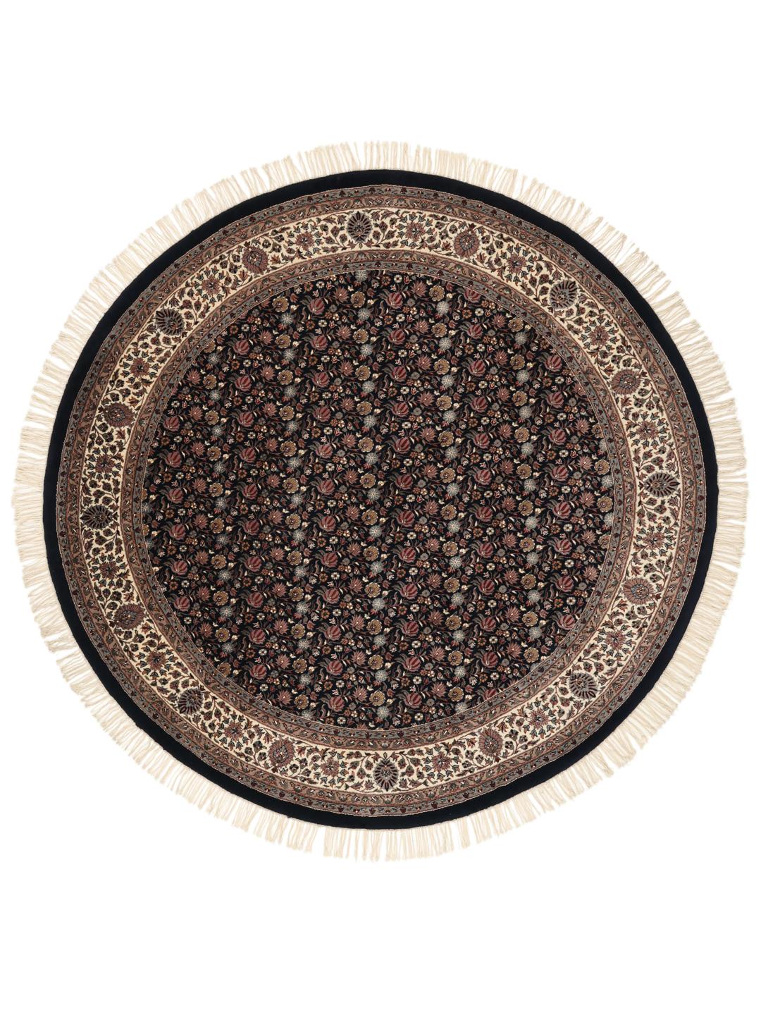 Rond handgeknoopt tapijt uit India met bloemmotieven in zwart en beige.