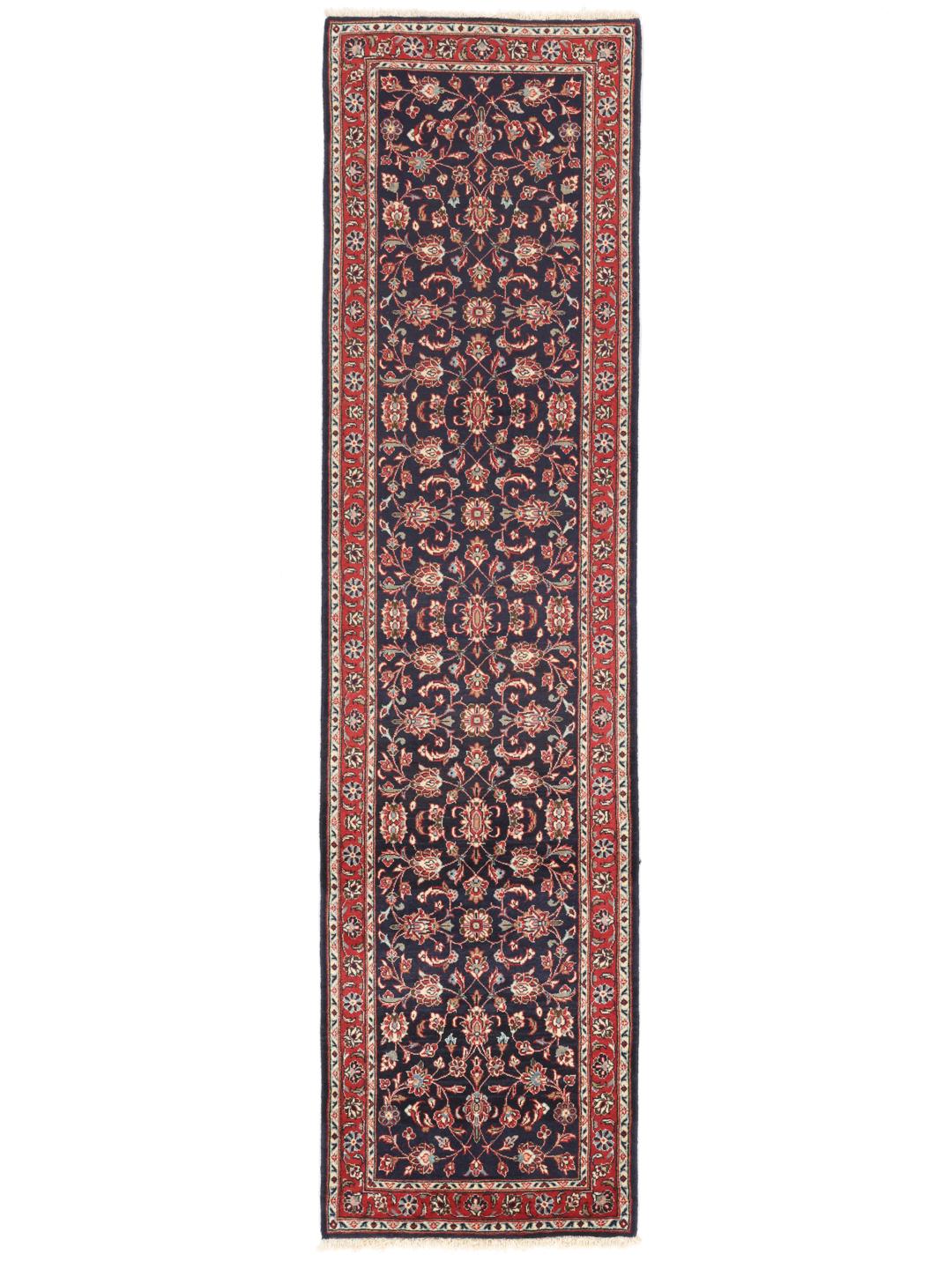 A hand-knotted Keshan runner with a dark blue field and intricate floral patterns.