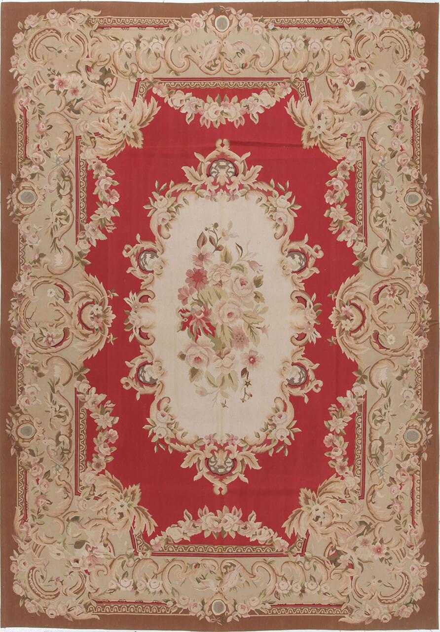 Håndvævet tæppe i Aubusson-stil med en blomstret medaljon i rød og creme, fremstillet i Kina.