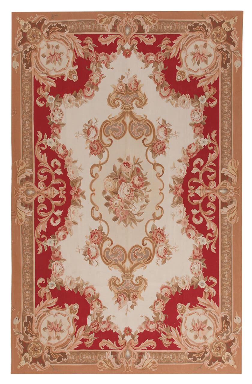 Et rektangulært håndvævet kelimtæppe med dekorative blomstermønstre i røde, elfenbensfarvede og beige toner fra Kina.
