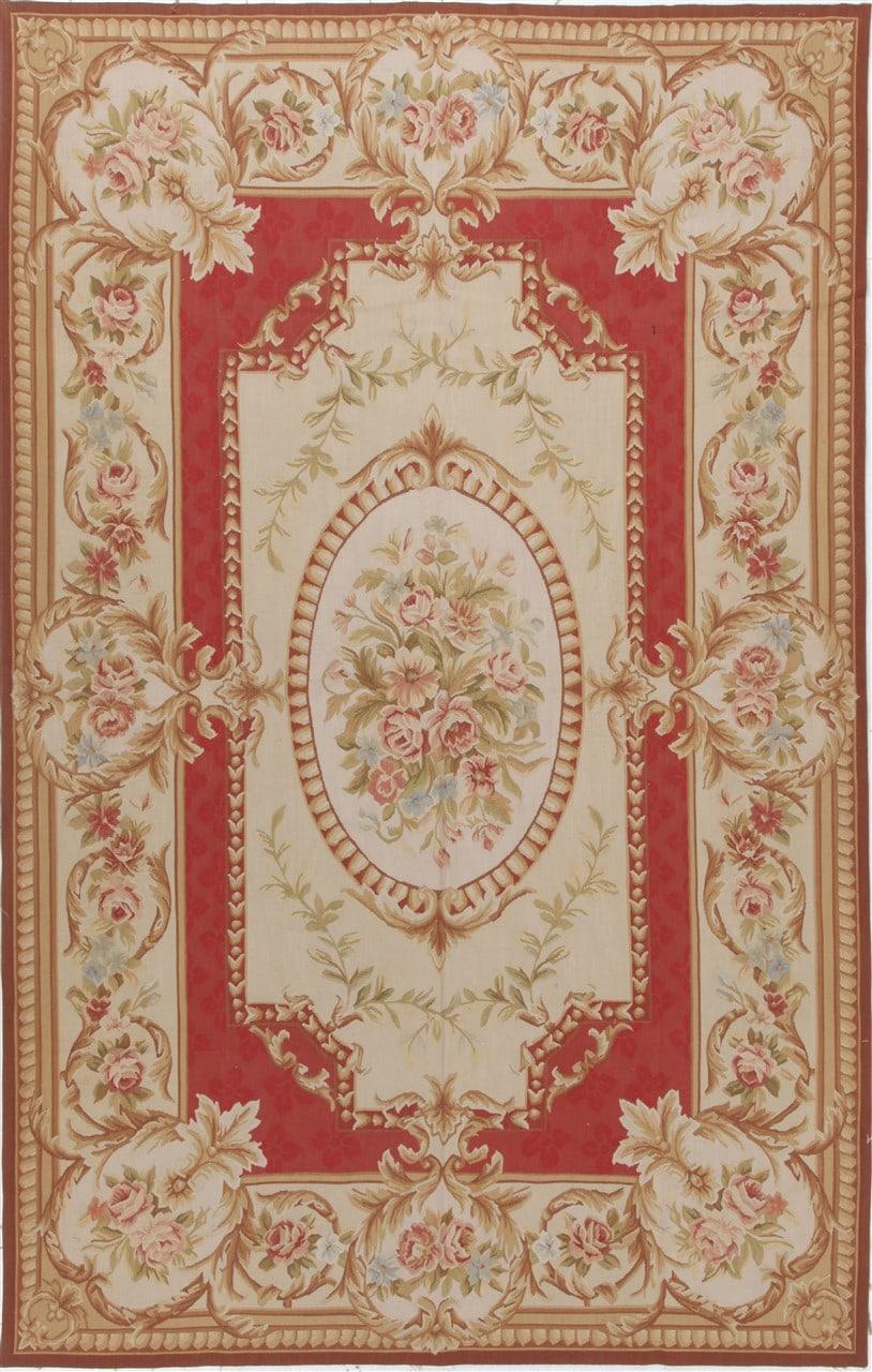 Et rektangulært, håndvævet tæppe fra Kina med et rødt og beige blomstermedaillon-design.