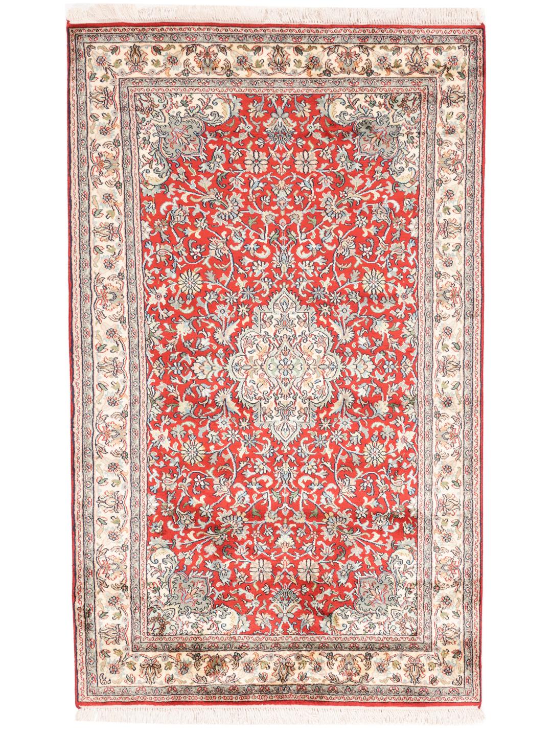 Et håndknyttet Kashmir-silketæppe fra Indien med et levende rødt felt og blomstermønstre.
