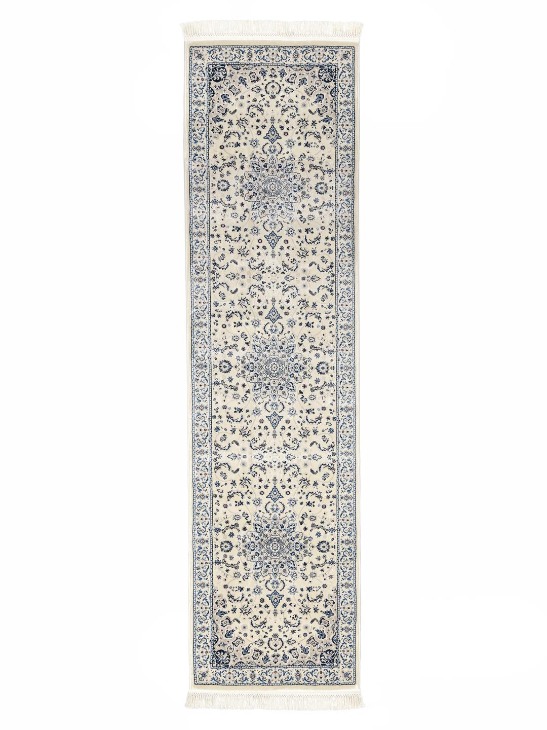 En lang creme-hvid løber med blå blomsterdetaljer