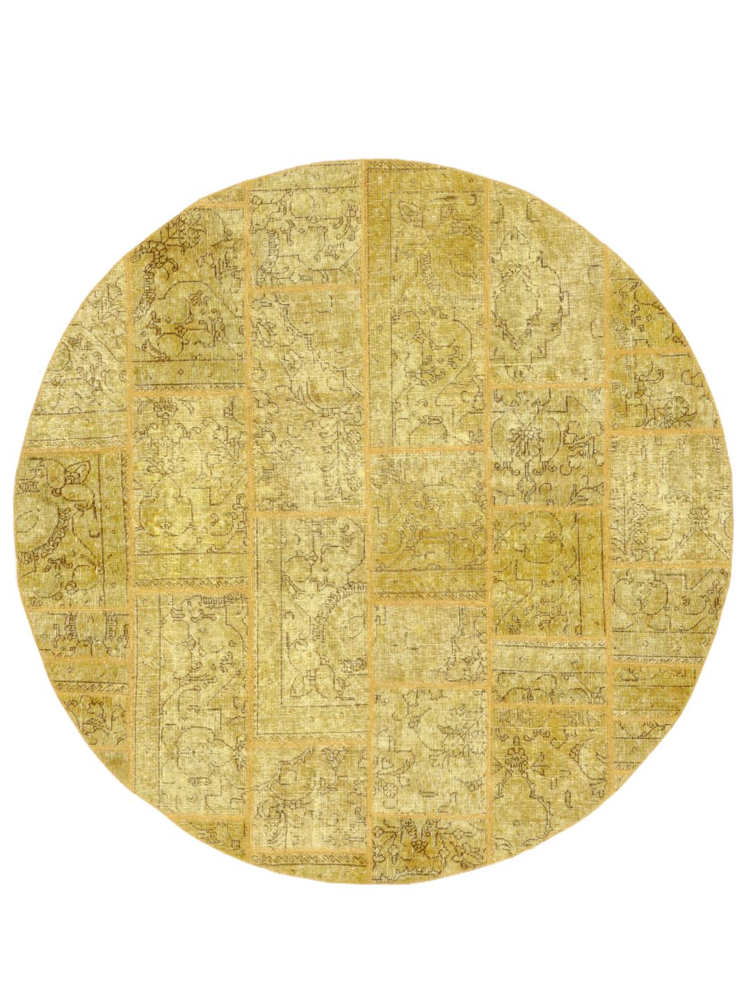 Een rond patchwork tapijt met een goudgeel kleurenpalet en vintage bloemmotieven.