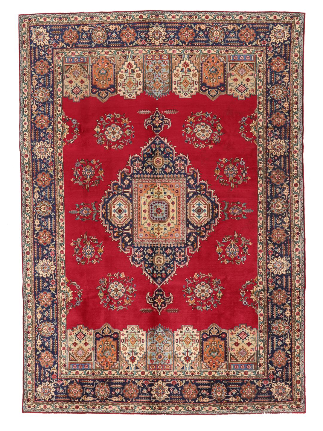 Een handgeknoopt Tabriz-tapijt uit het Midden-Oosten met een levendig rood veld en een centraal medaillon.