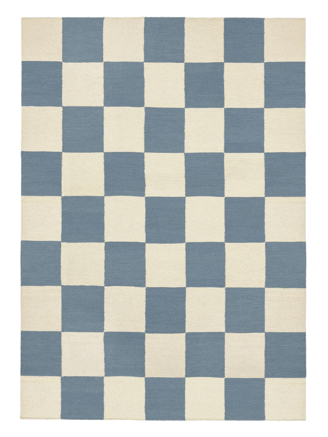 Een handgeweven wollen tapijt in blauw en wit met een dambordpatroon.