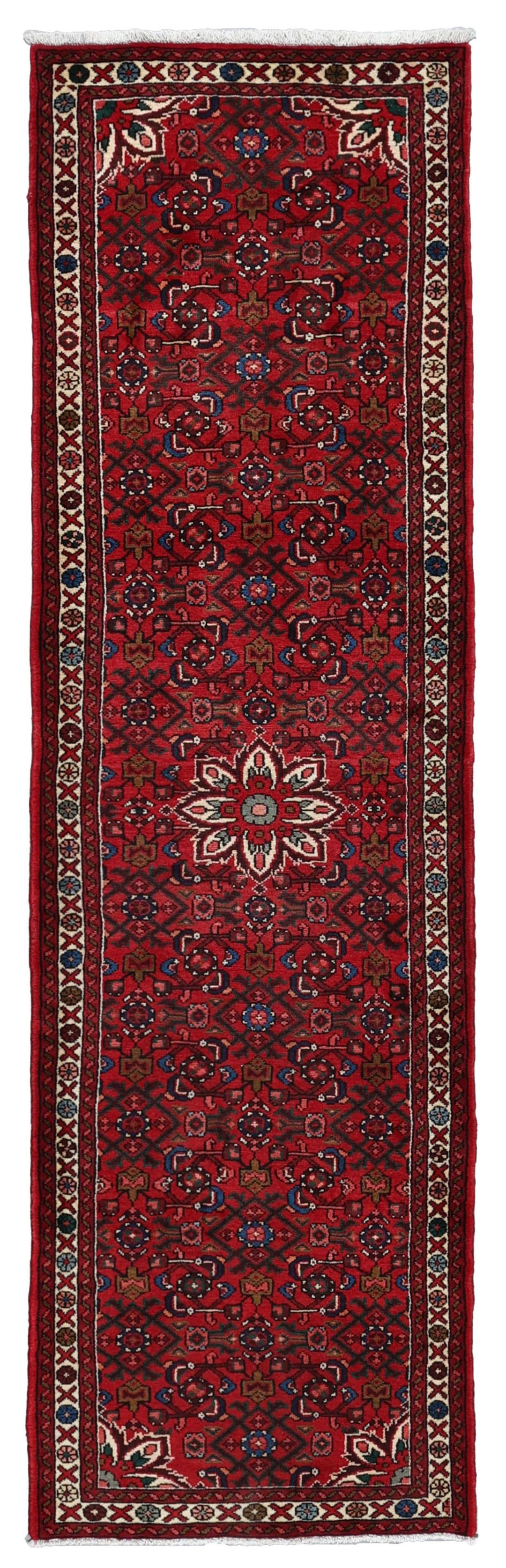 A hand-knotted runner rug from the Middle East featuring a deep red field and geometric motifs