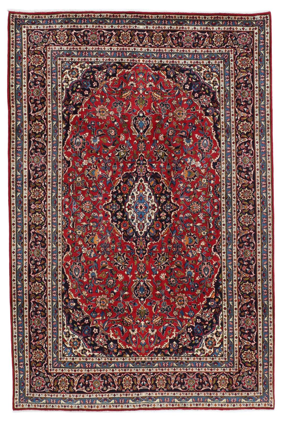 A hand-knotted Mashad rug from the Middle East in deep red and blue tones.