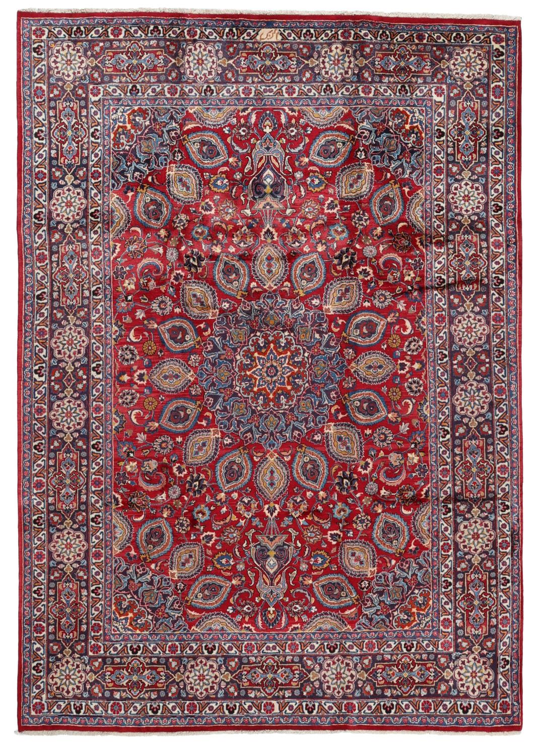 A large rectangular Mashad rug from the Middle East in deep red with floral medallion patterns.
