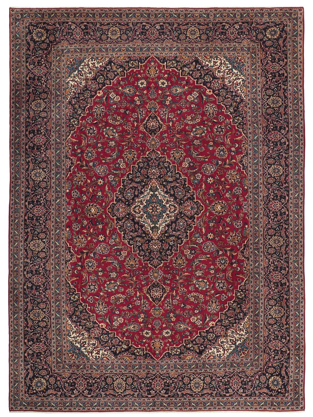 A large rectangular hand-knotted Keshan rug from the Middle East in red and dark blue.
