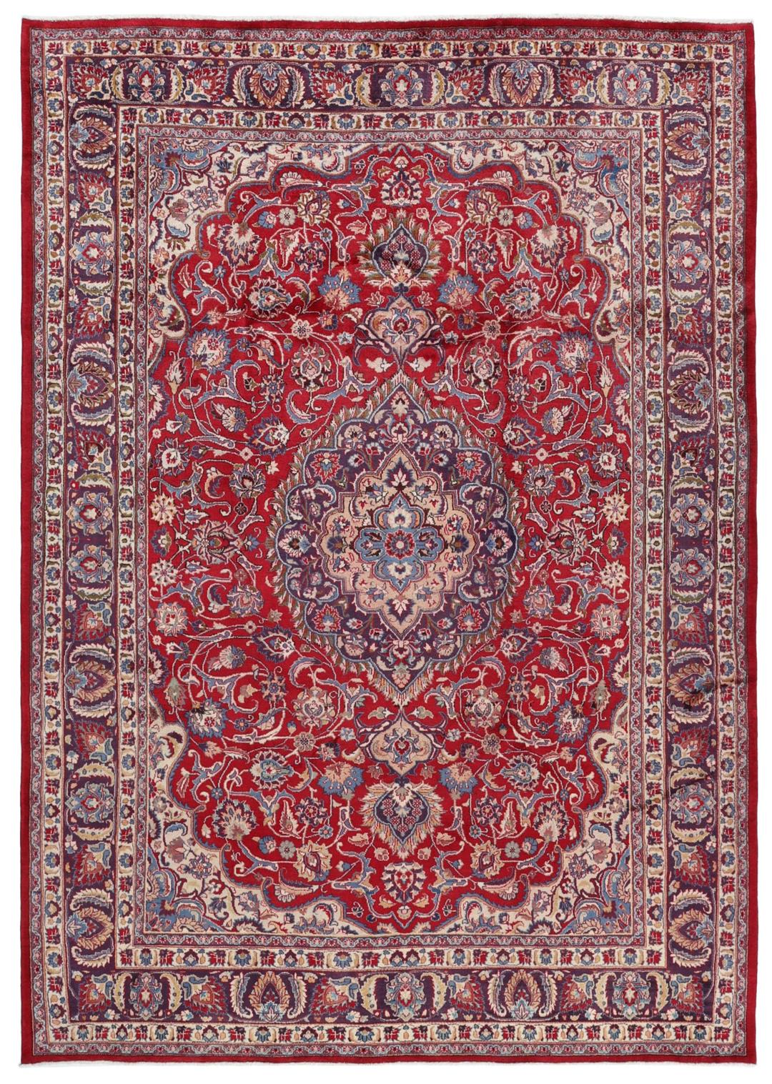 Een handgeknoopt Mashad-tapijt uit het Midden-Oosten met een rood veld en een gedetailleerd bloemmedaillon.