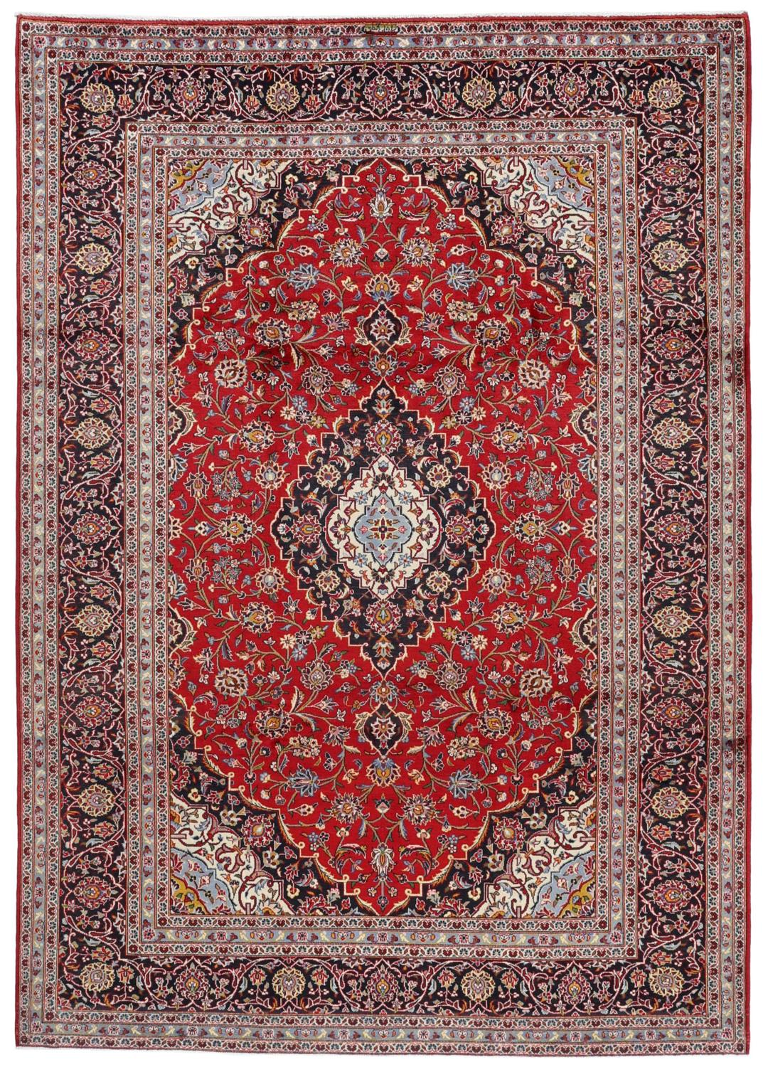 A hand-knotted Keshan rug with a red field and traditional floral medallion from the Middle East.