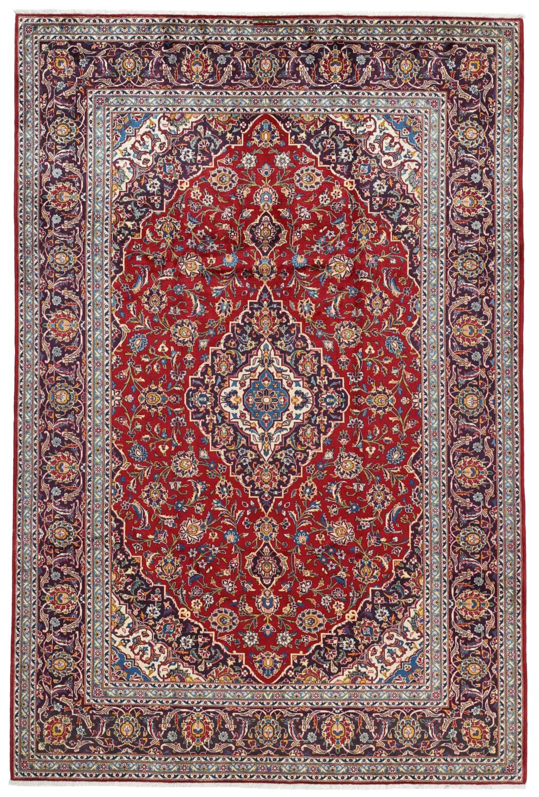 A beautiful red Keshan rug with a central medallion and intricate floral patterns.