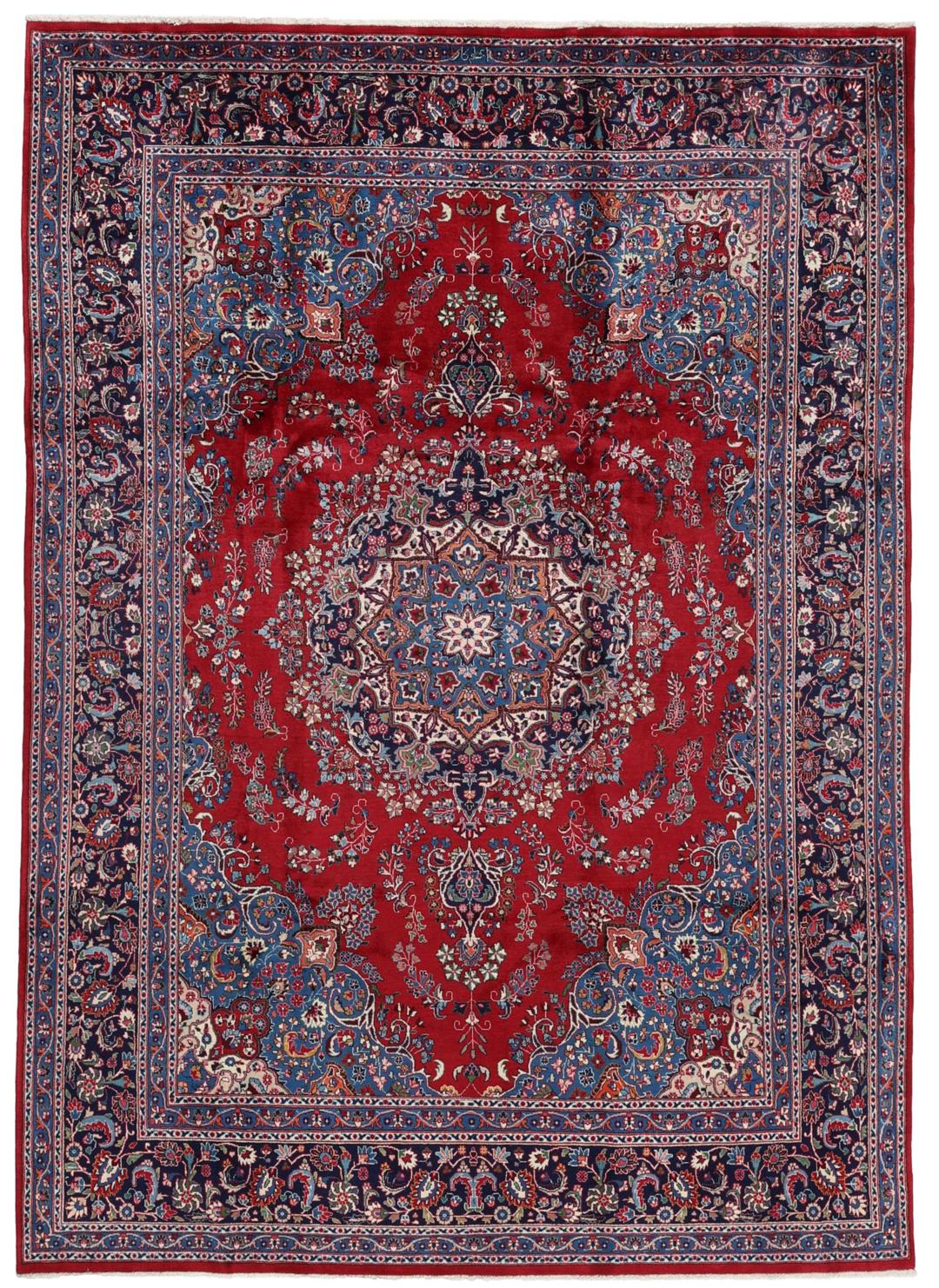 Un tapis Mashad noué main provenant du Moyen-Orient avec un champ rouge profond et des motifs floraux.