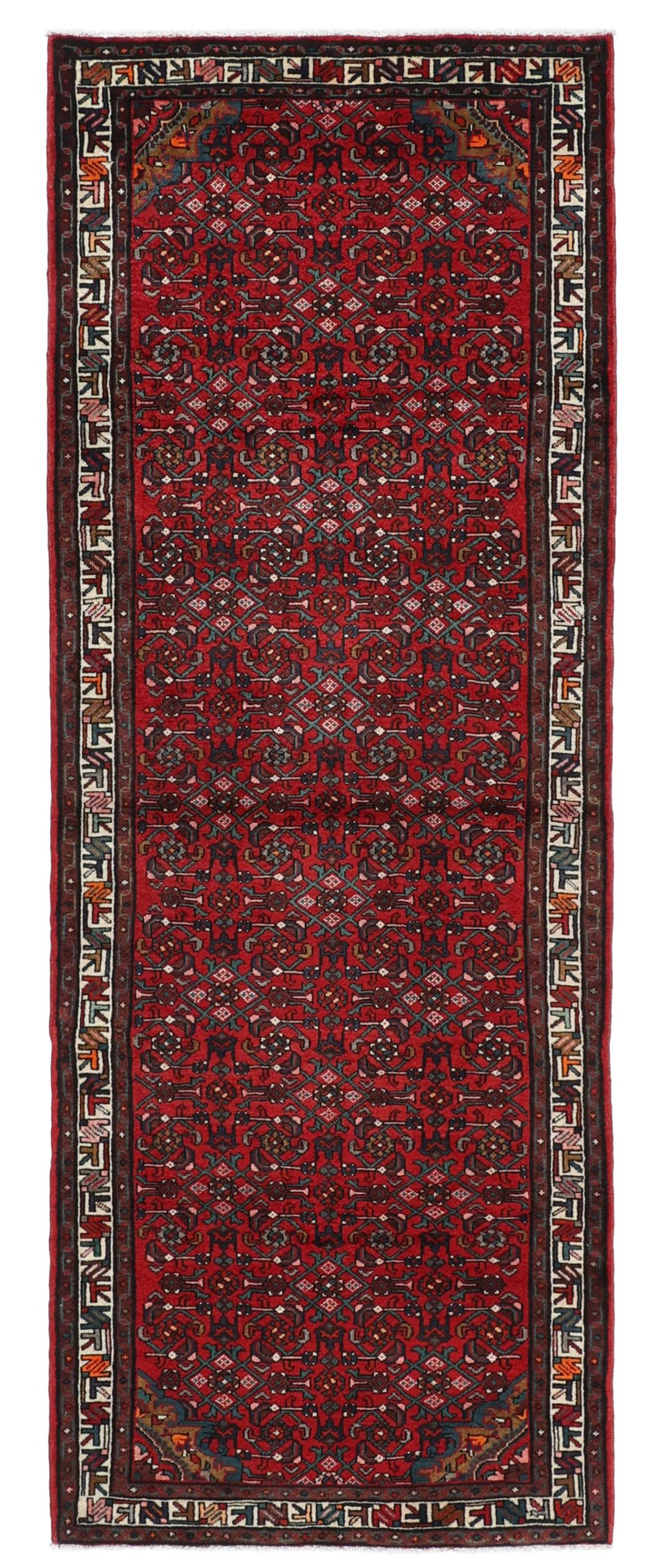 A hand-knotted Hosseinabad runner with a deep red field and geometric patterns from the Middle East.