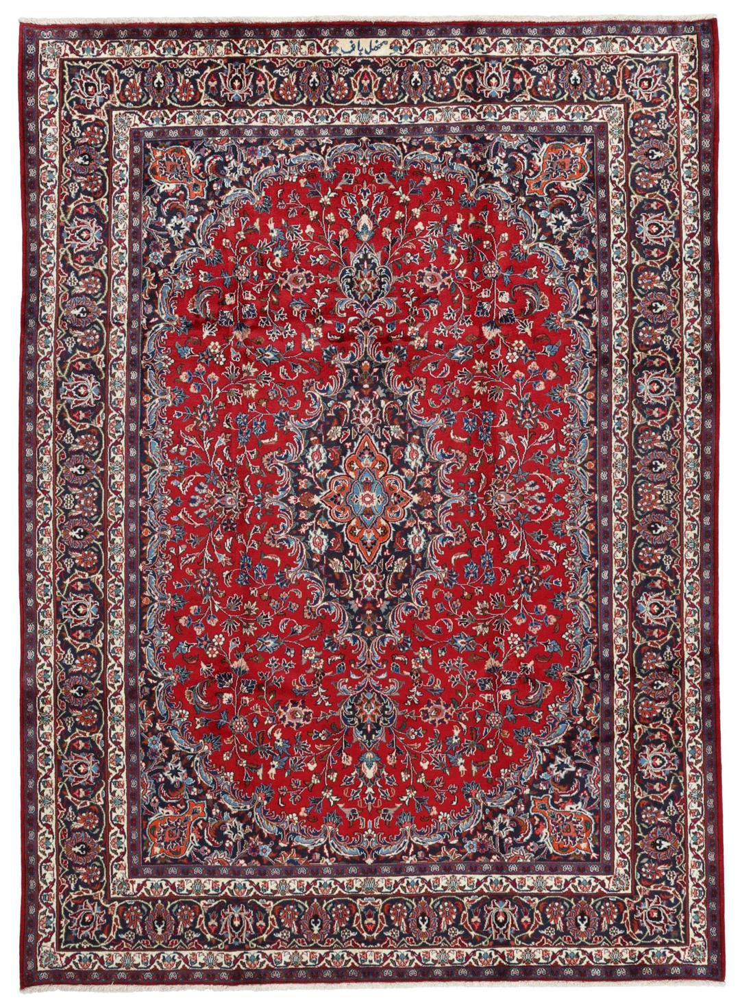 A hand-knotted Mashad rug from the Middle East in deep red and navy tones.