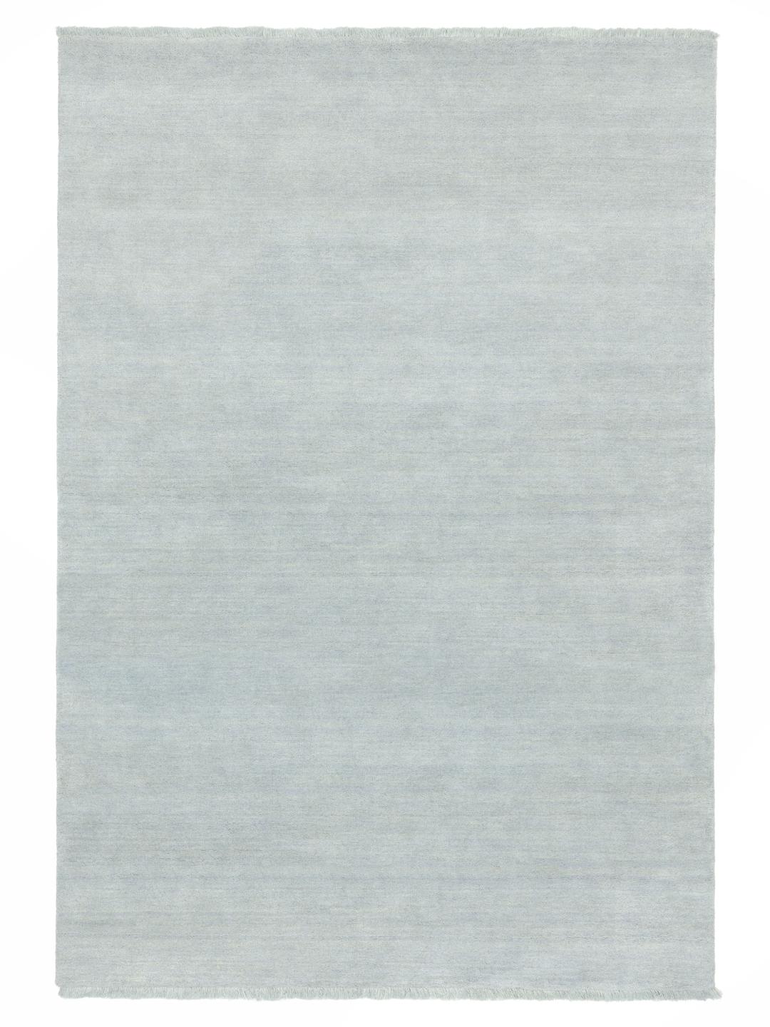 Een blauw hoogpolig tapijt met korte franjes aan de randen
