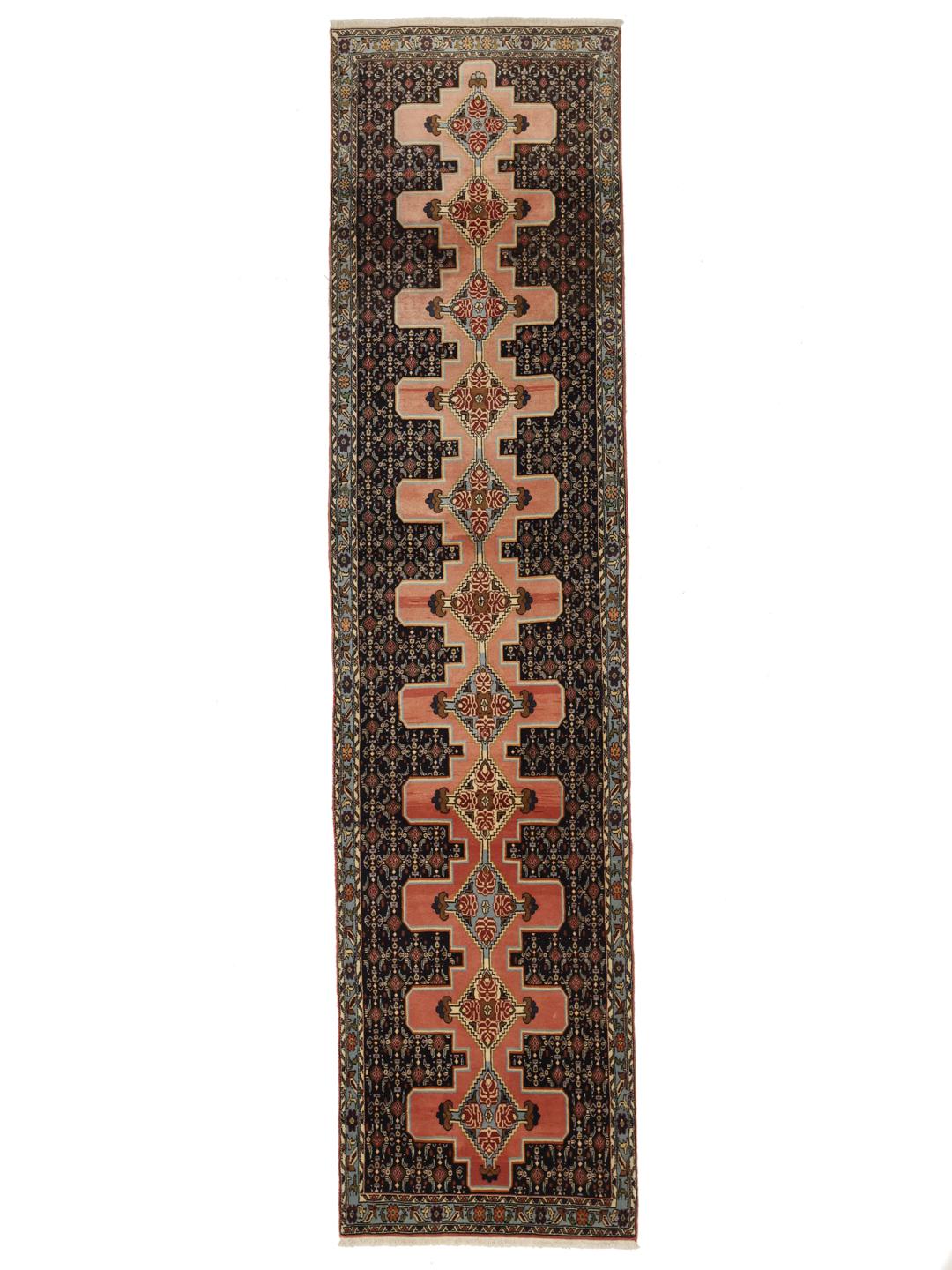 A hand-knotted Senneh runner with a multicolored diamond pattern on a dark field.