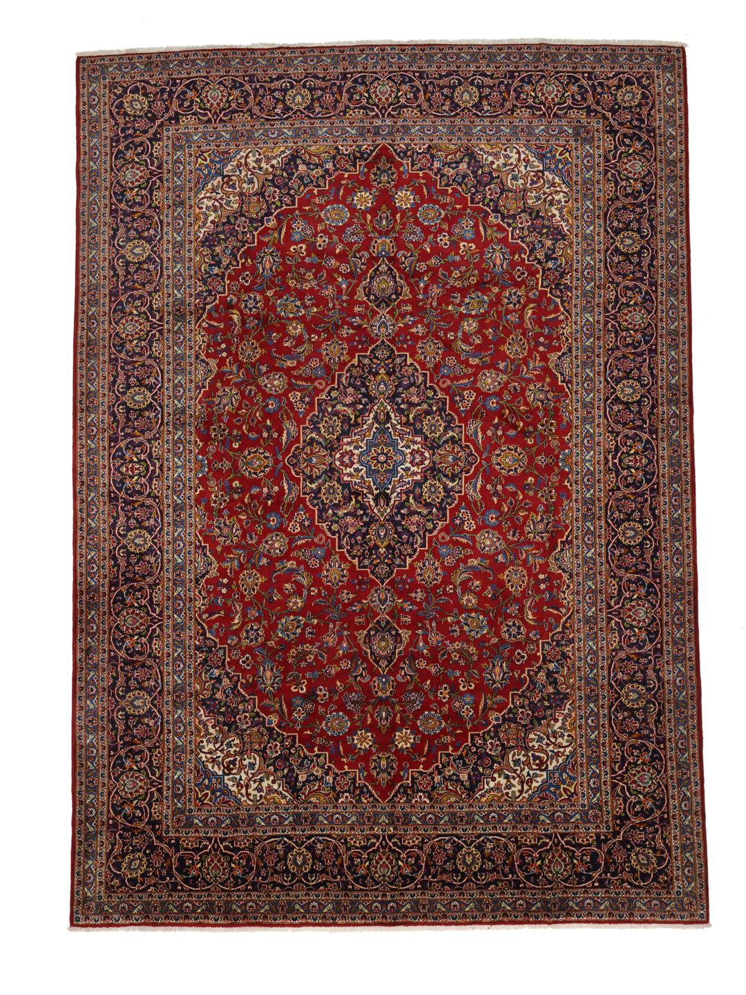 A large, hand-knotted Keshan rug from the Middle East with a red field and ornate floral patterns.