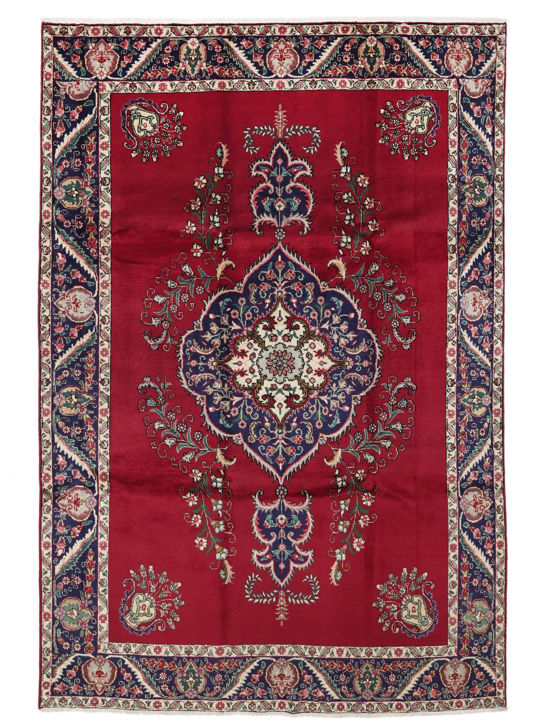 Handmade Tabriz rug with a red field and intricate blue floral medallion from the Middle East