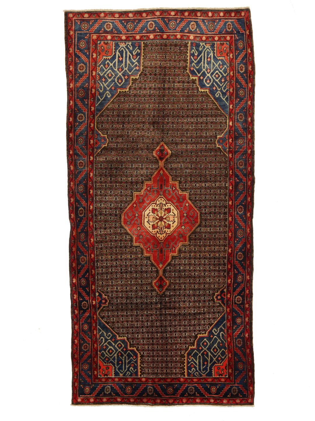 Een handgeknoopt Koliai tapijt met ingewikkelde geometrische motieven in diepblauw, rood en bruin.
