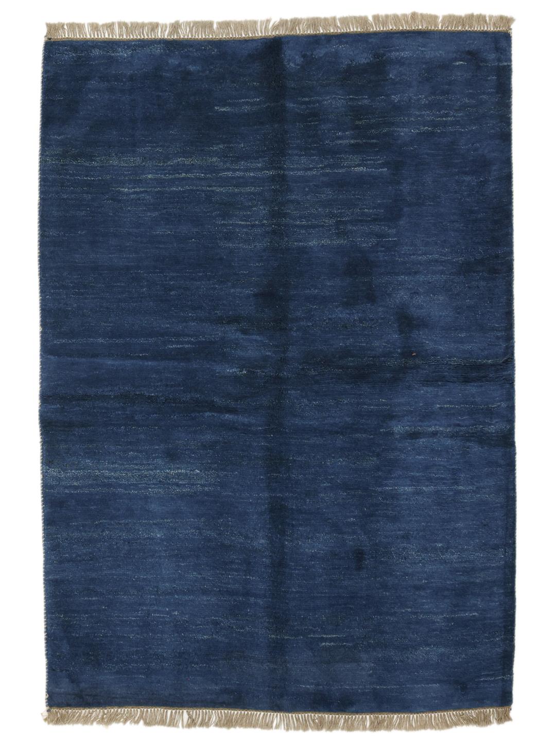 Een diepblauw handgeknoopt Gabbeh-tapijt uit het Midden-Oosten met een zachte wollen textuur.