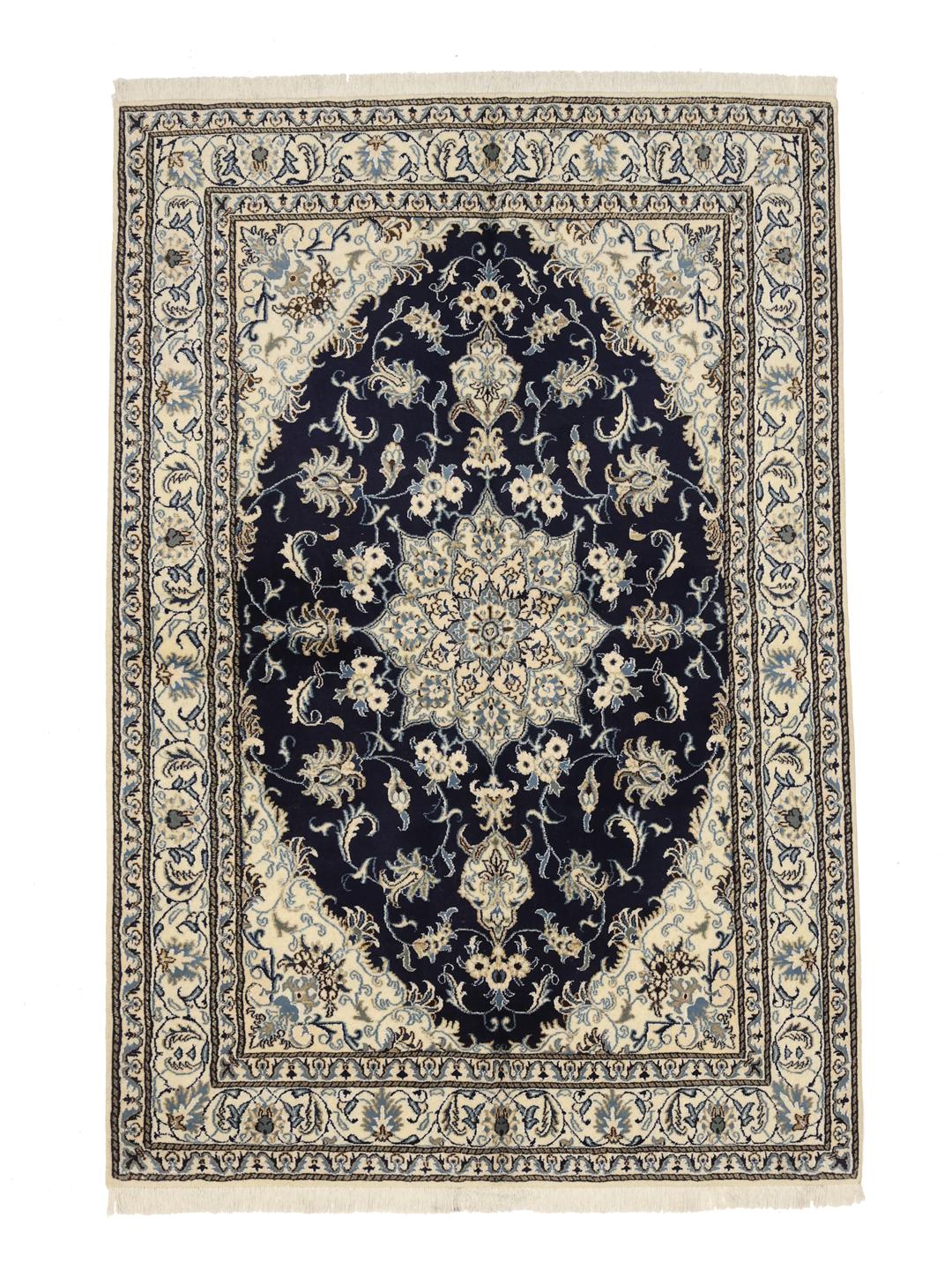 A hand-knotted rug from the Middle East with a dark-blue field and floral patterns.