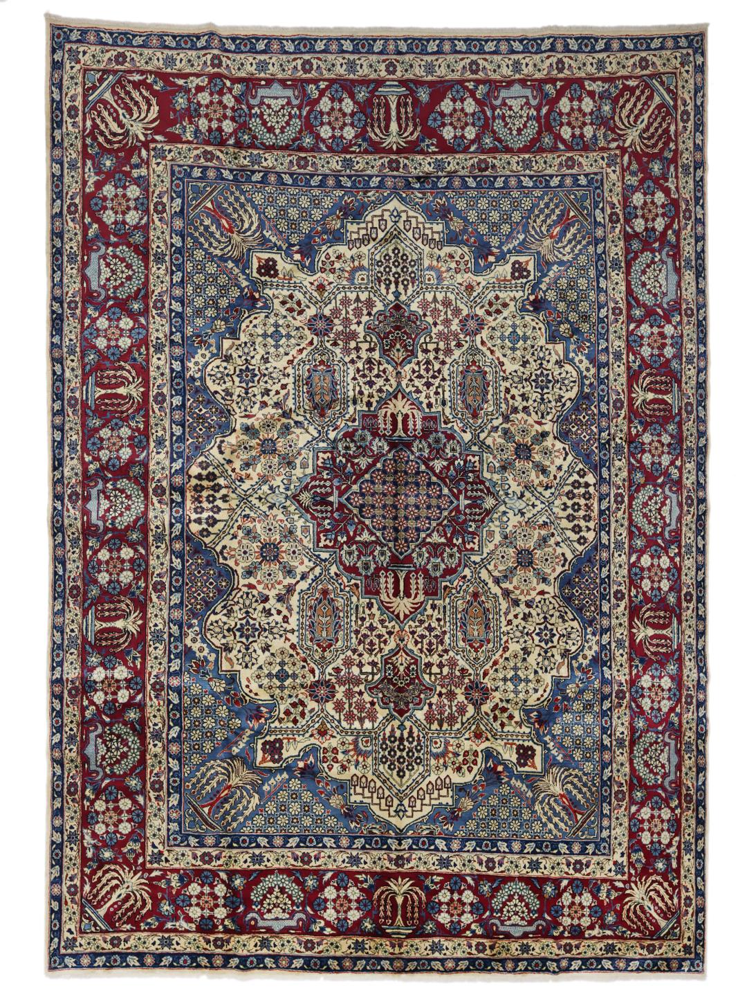 Een groot rechthoekig handgeknoopt Yazd-tapijt uit het Midden-Oosten met een rood en blauw bloemenpatroon.