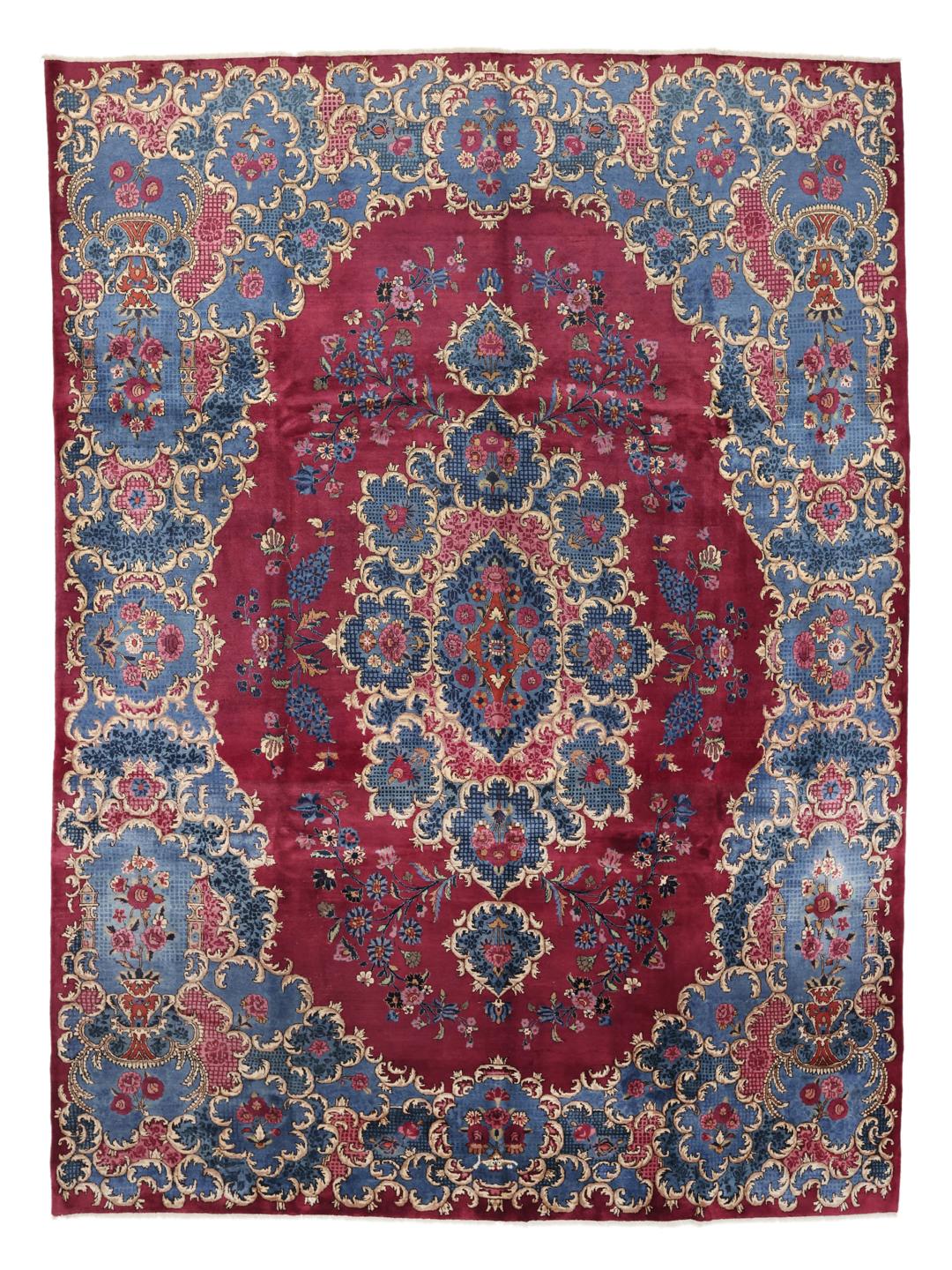 Een groot, handgeknoopt Mashad-tapijt uit het Midden-Oosten met een rood en blauw bloemenpatroon.