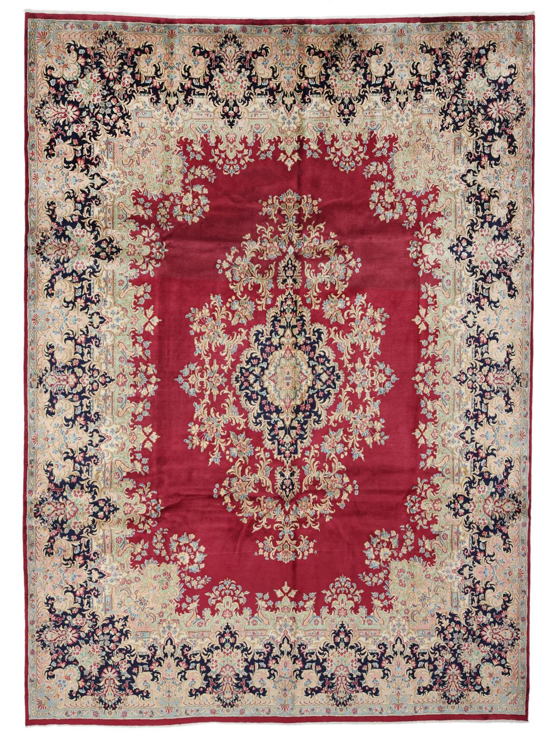 A hand-knotted Kerman rug from the Middle East with a dark-red field and floral patterns.
