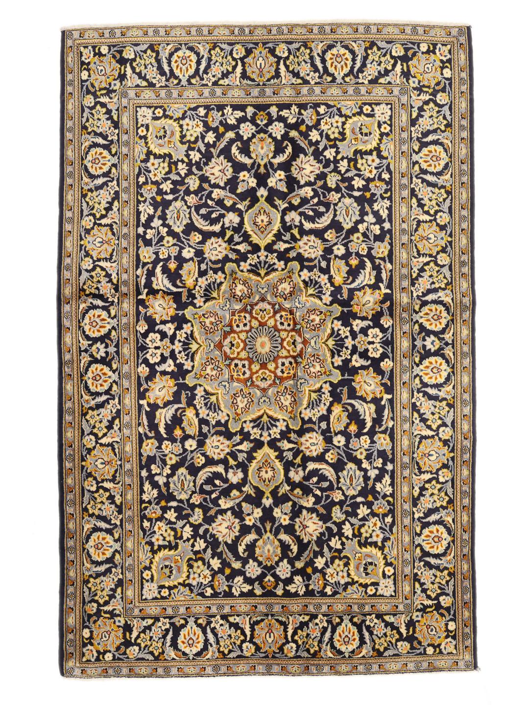 Een handgeknoopt Keshan-tapijt uit het Midden-Oosten in donkerblauw met bloemmotieven.