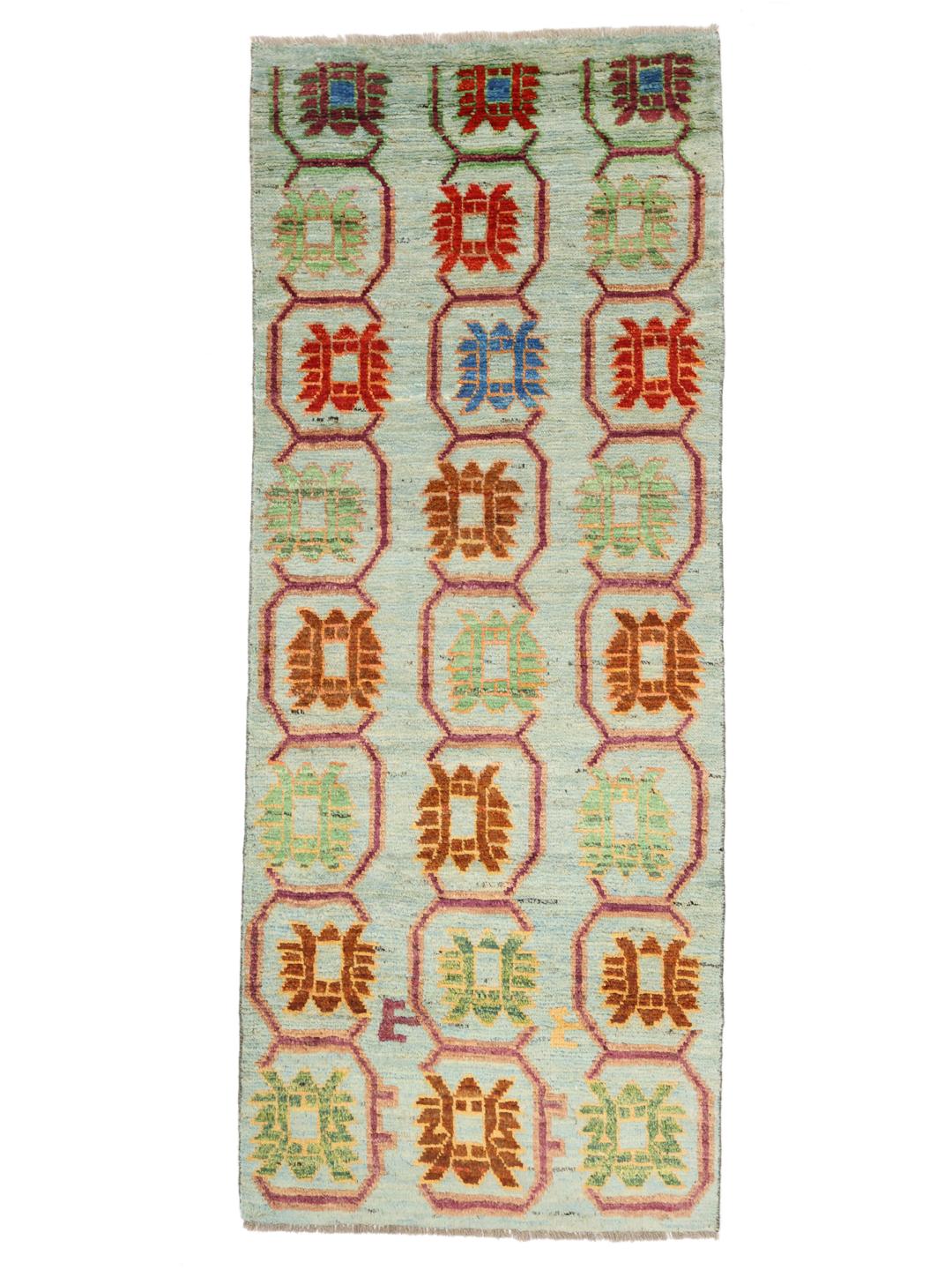 A hand-knotted Afghan runner with a vibrant geometric pattern on a light blue background.