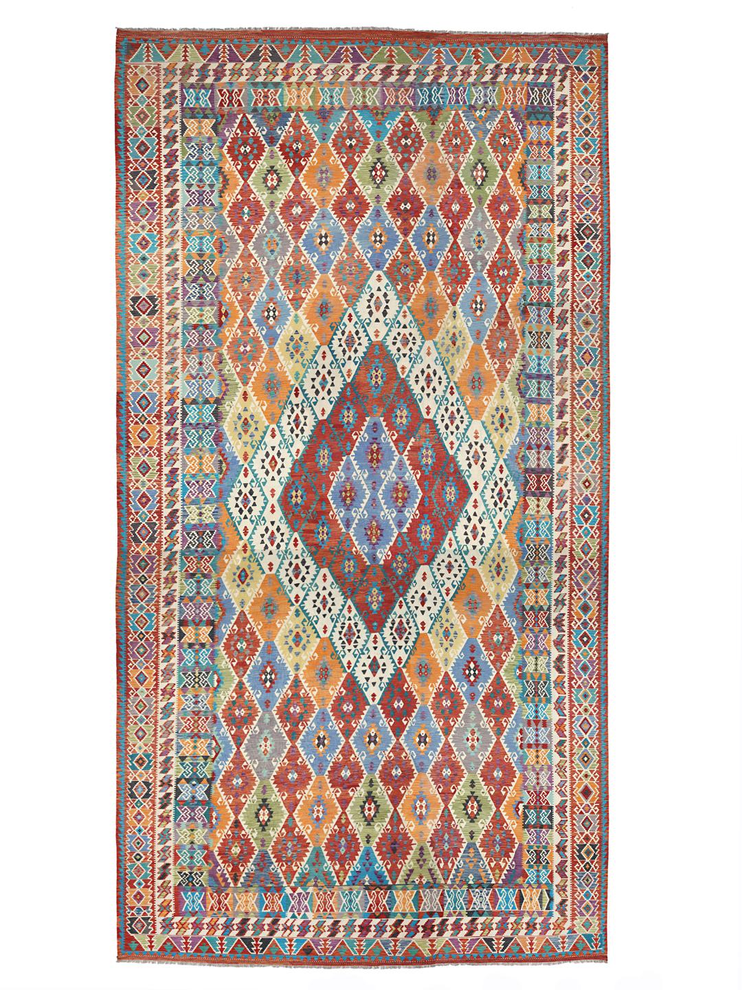 A large, colourful hand-woven Afghan Kelim rug with geometric diamond patterns.
