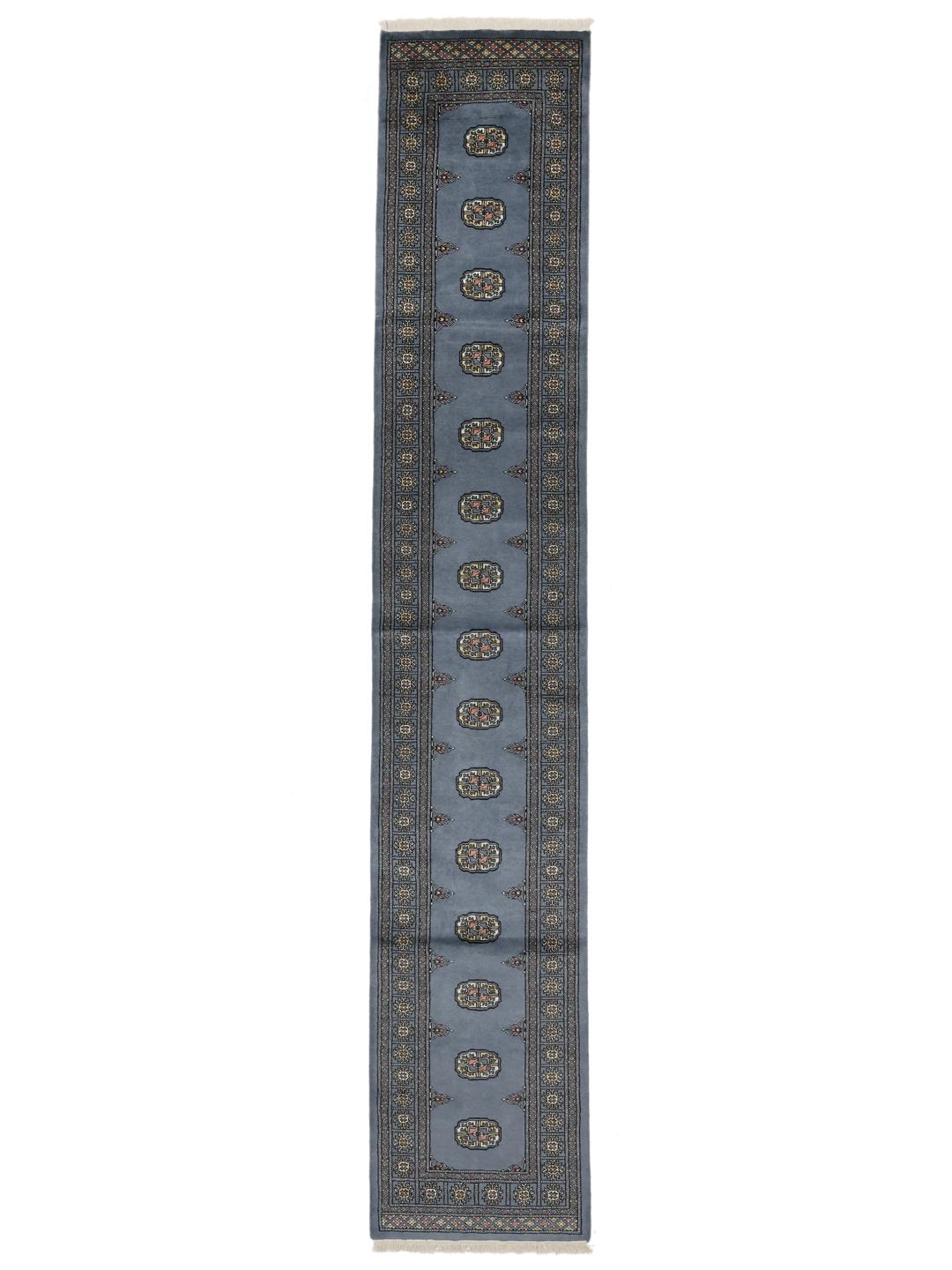 A long, hand-knotted blue runner rug from Pakistan with traditional patterns.
