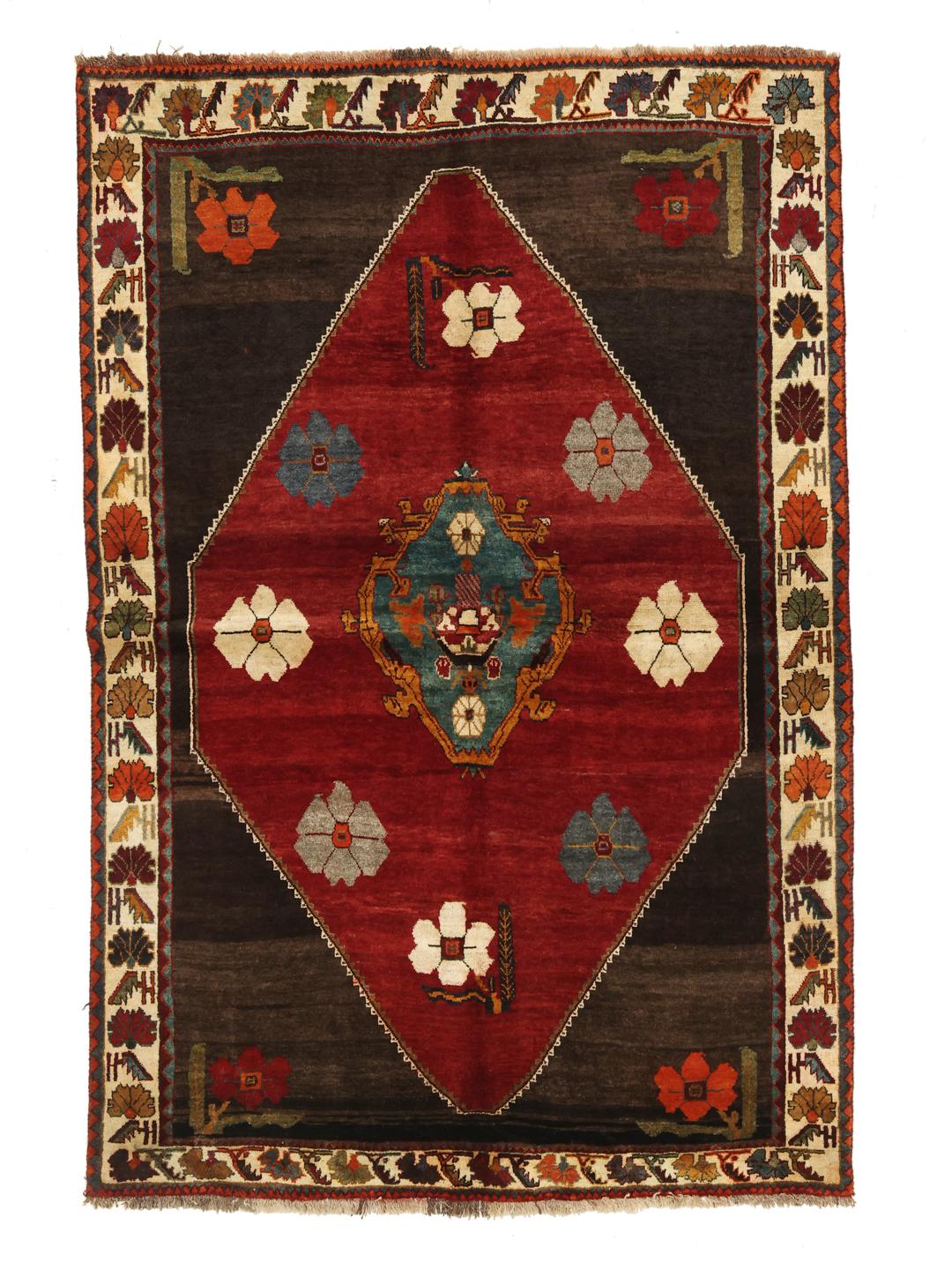A hand-knotted Shiraz rug from the Middle East featuring a dark red field with floral motifs in a vibrant, decorative style.