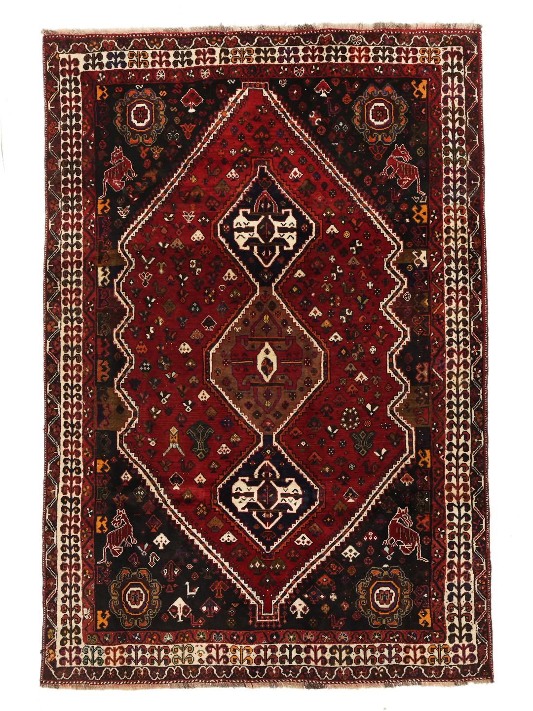 A hand-knotted Shiraz rug from the Middle East featuring a vibrant red and black geometric design.